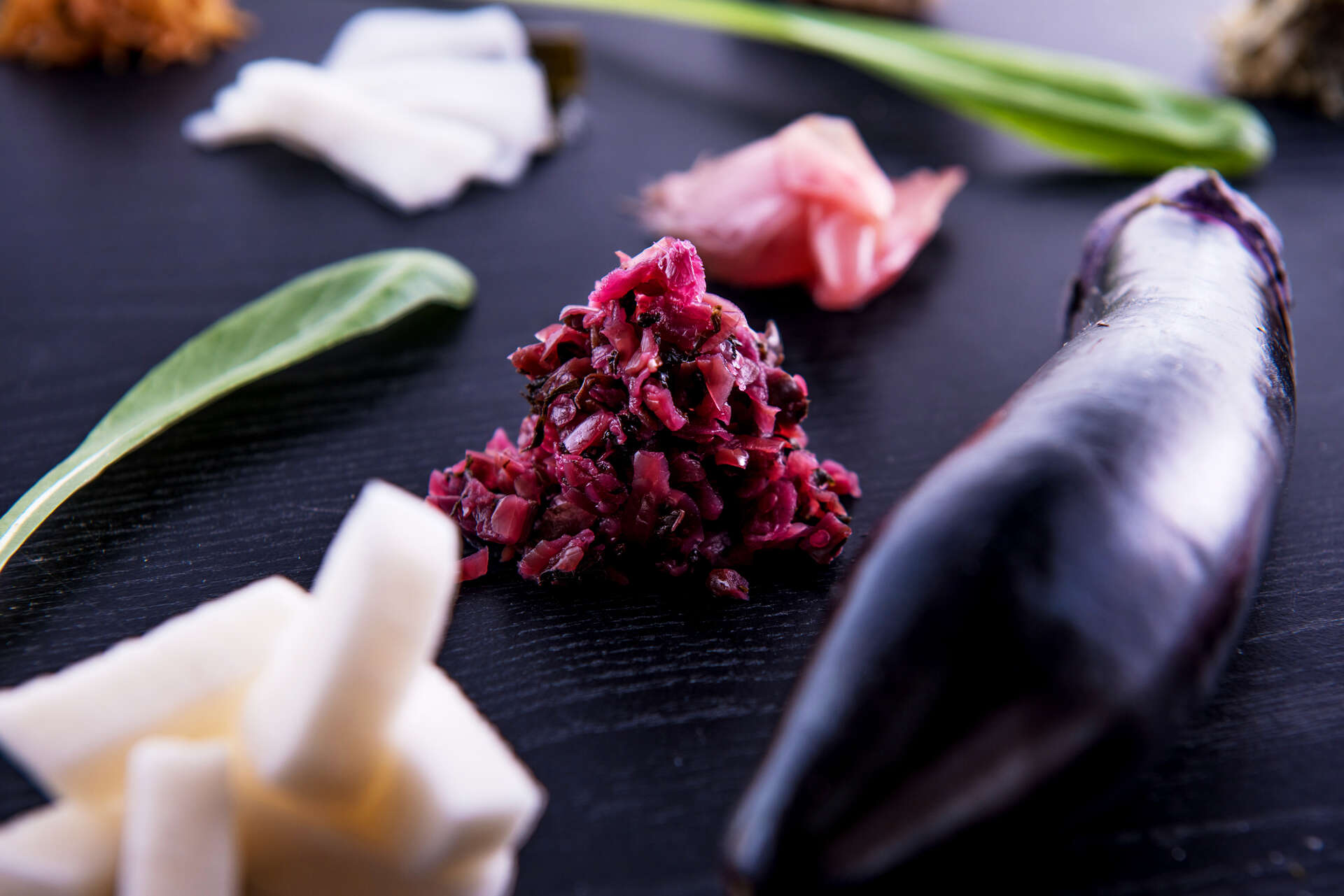 しば漬けと白い漬物を黒い台の上に盛り付けた写真