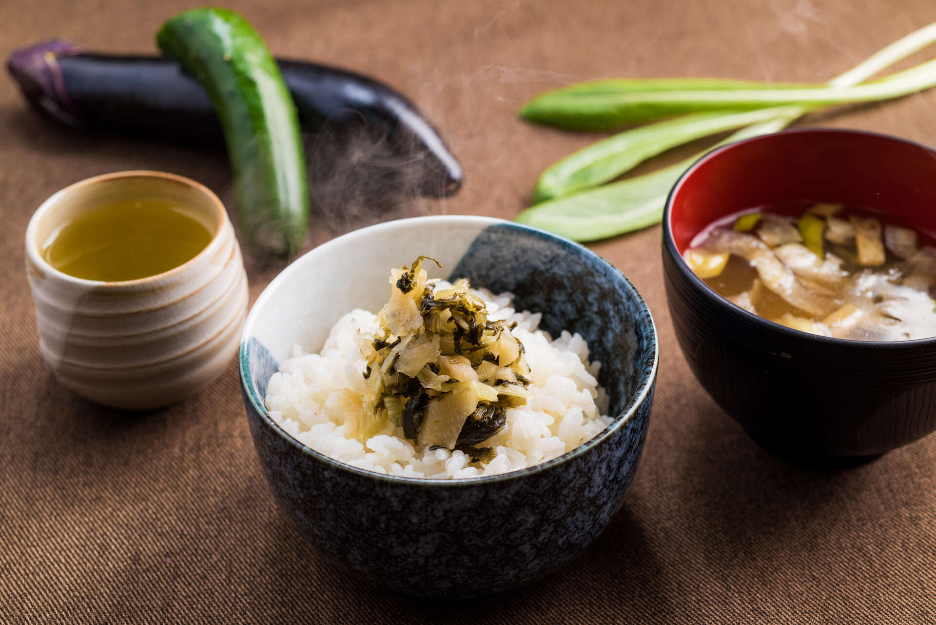 ご飯と味噌汁に漬物を添えた食卓の写真